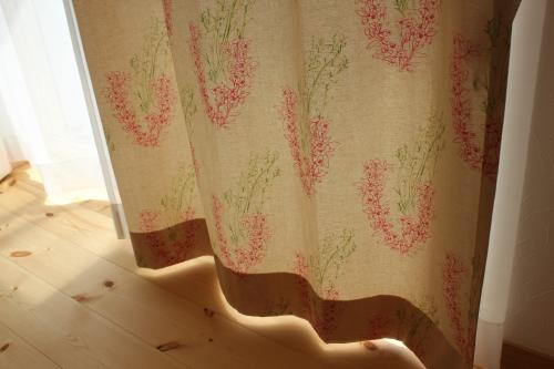 ベージュにピンクの花柄のカーテンの裾の部分