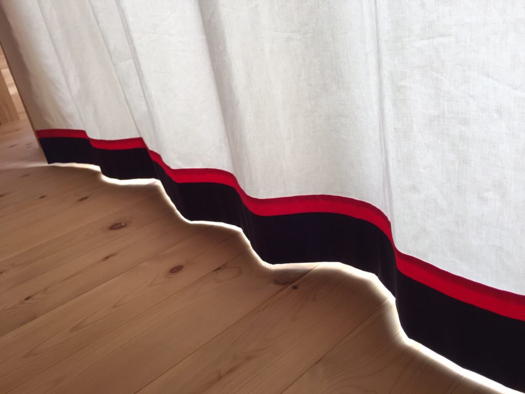 カーテンの裾部分。白色の下段に赤、青色が使われている